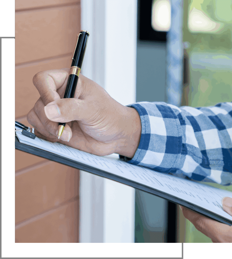 Person writing notes on a clipboard outdoors.
