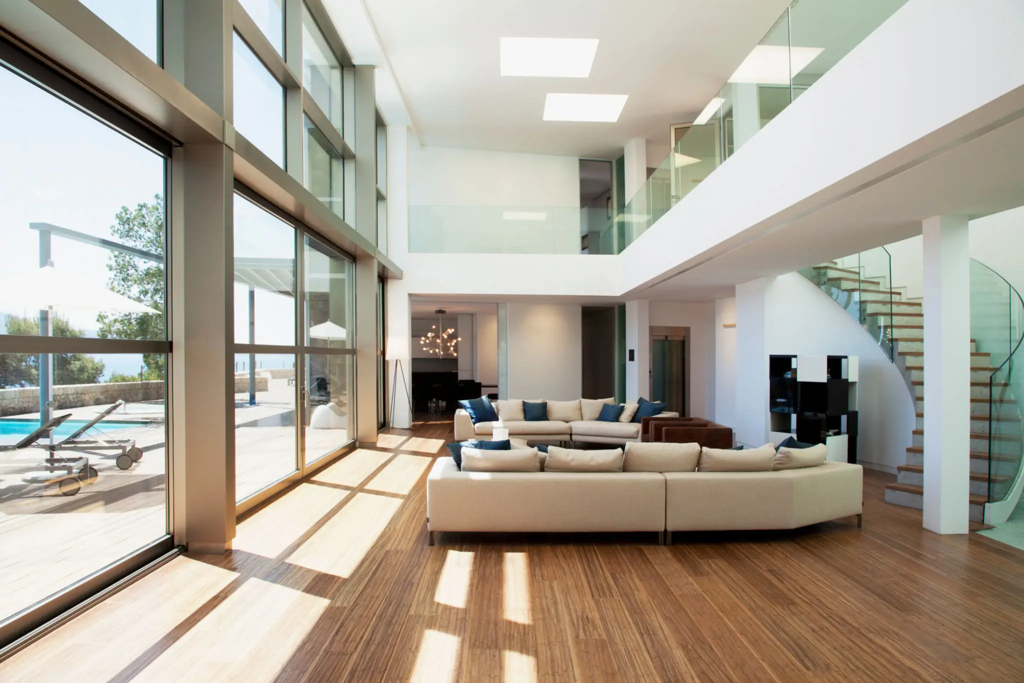 Bright modern living room with large windows and wooden flooring.