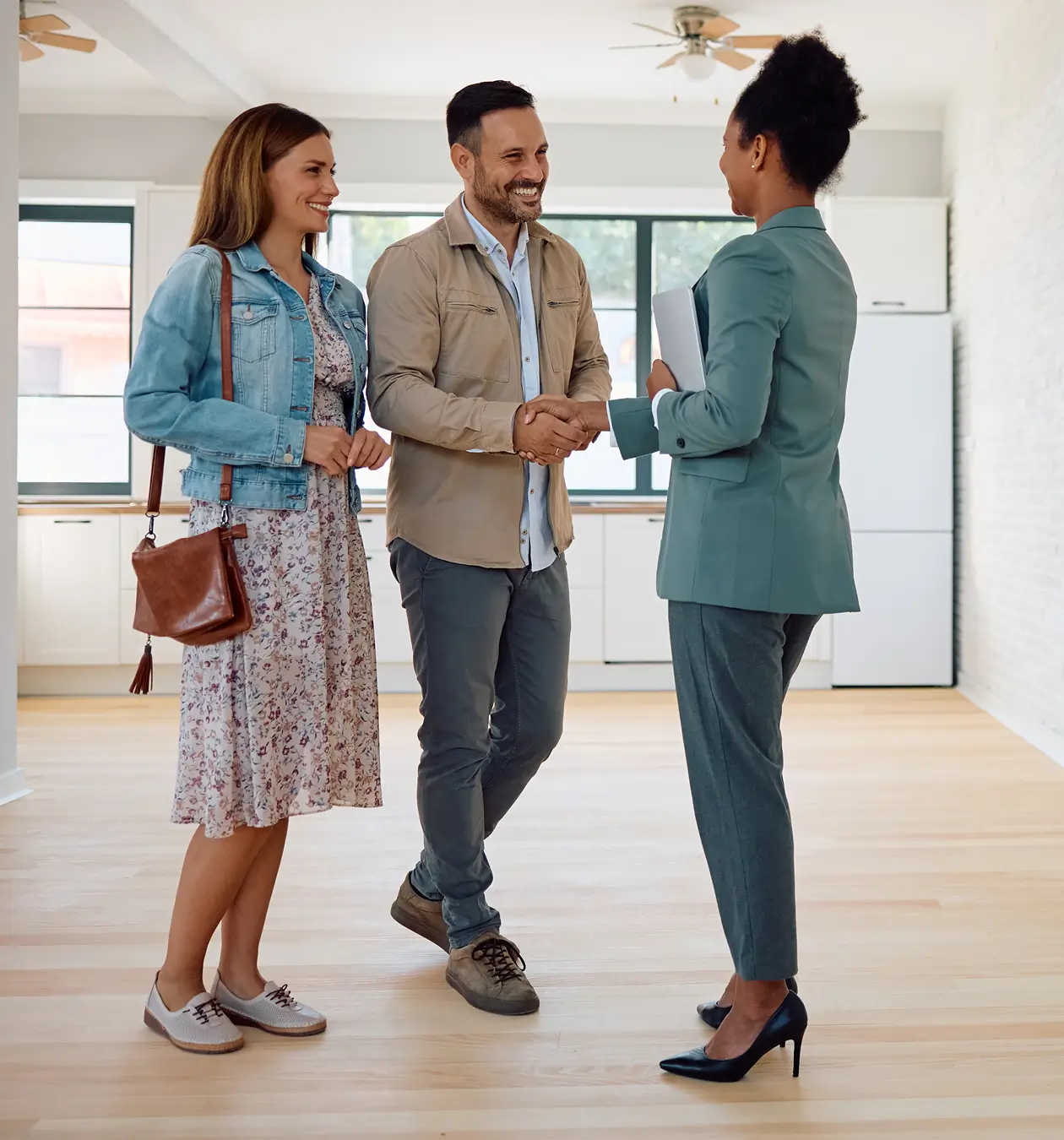 Realtor shaking hands with prospective homebuyers.